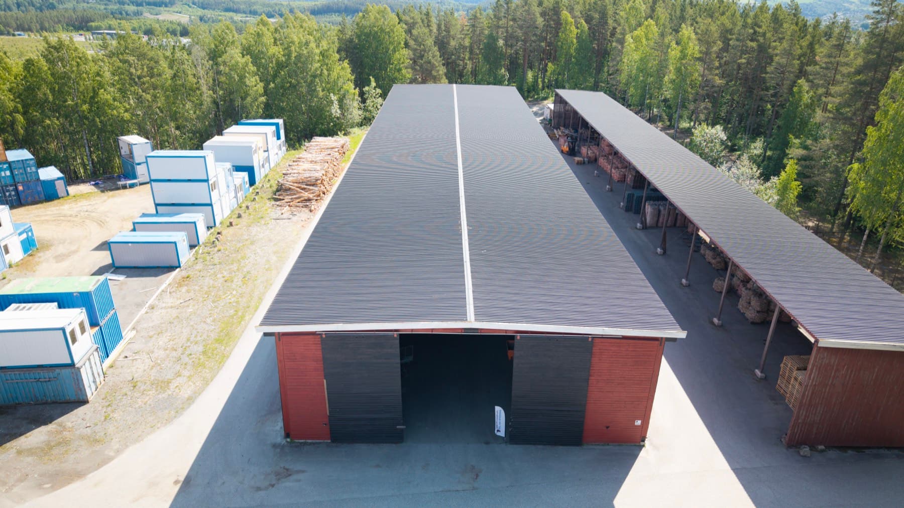 Det lange lagerbygget sett ovenfra, med modul- og containerområdet til venstre og det åpne tømmerskuret til høyre